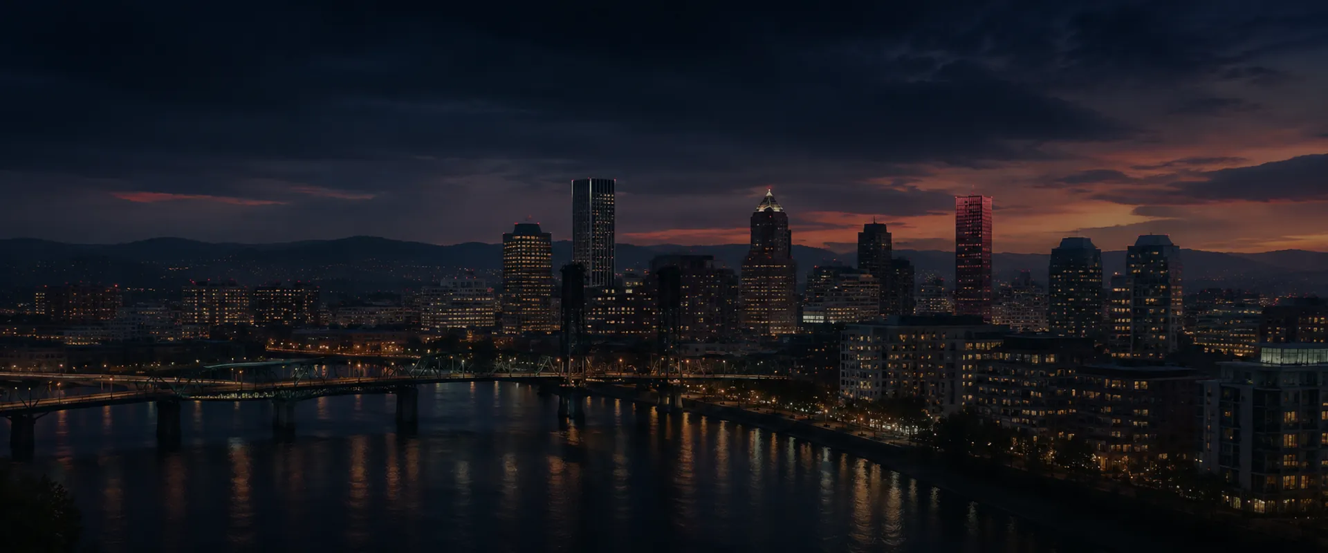Portland skyline glowing across the Willamette River at dusk